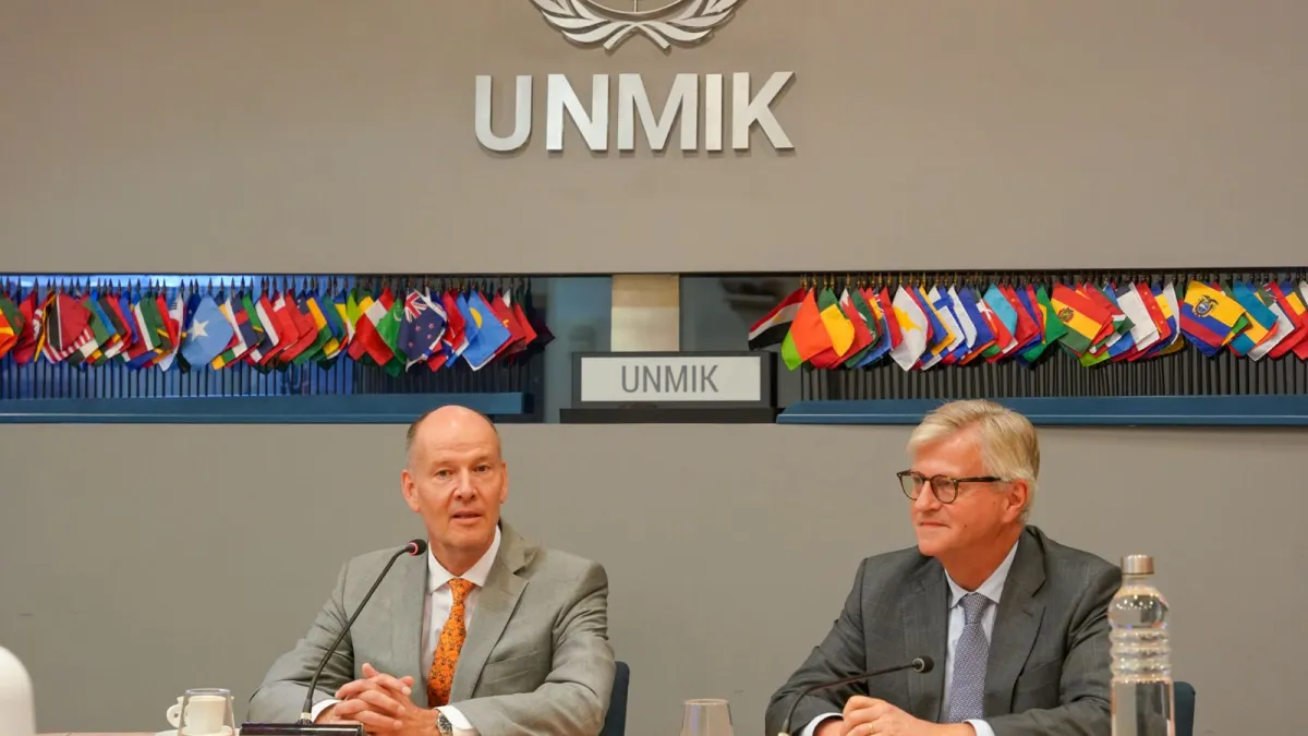 Two men sitting at a roundtable in front of mics