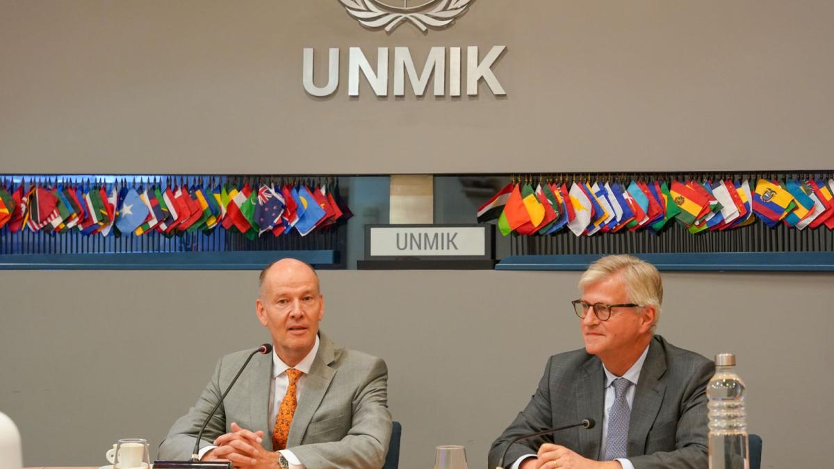 Two men sitting at a roundtable in front of mics