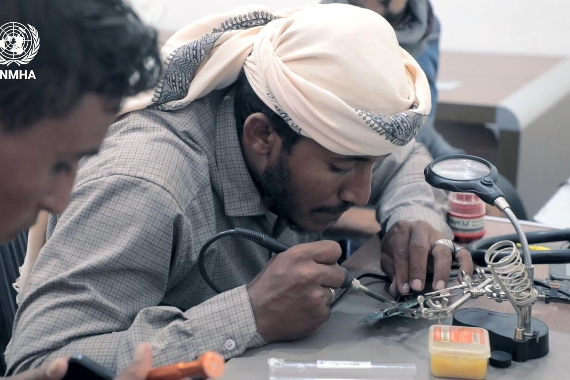 A man receives training in mobile phone repair