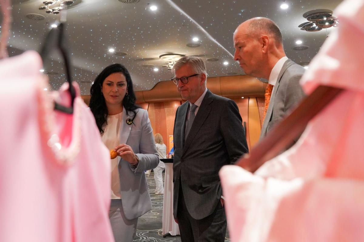 Two men and one woman looking at some products 