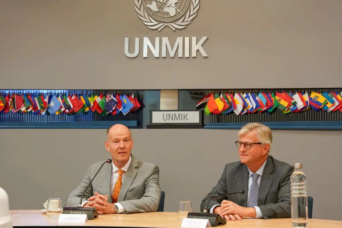 Two men sitting at a roundtable in front of mics