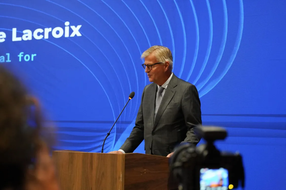 Man speaking into a microphone at a podium 