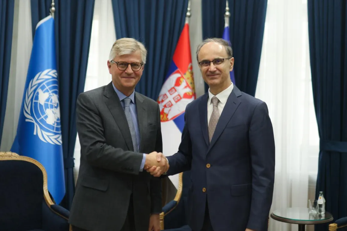 Two men shaking hands in front of flags 